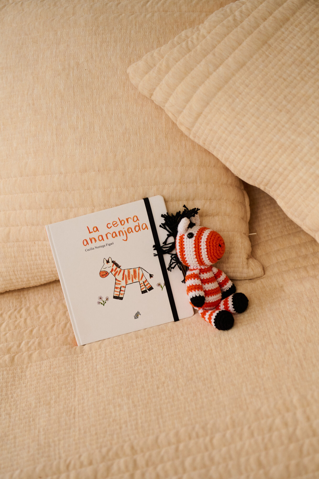 La cebra anaranjada en la cama con su cebra de crochet